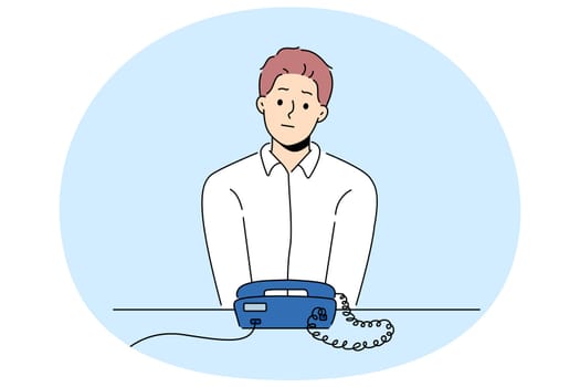 Unhappy man sit at desk look at landline phone waiting for someone call. Frustrated guy awaiting ring looking at corded telephone. Vector illustration.