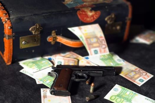 a close up of colt 1911, ammos and money, suitcase on background