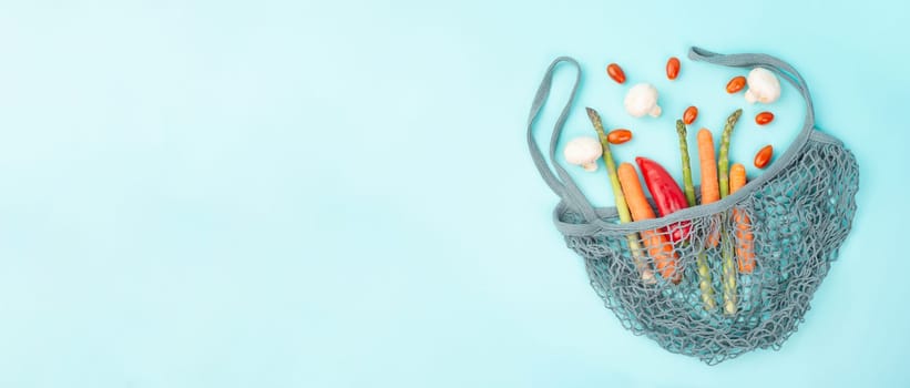 Mesh bag with vegetables, shopping grocery, healthy food ingredients, asparagus sprout, mushrooms, carrots and tomatoes, zero waste