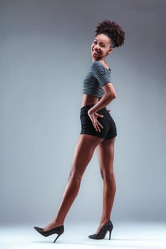 Fashion-forward young lady elegantly poised in sparkling heels