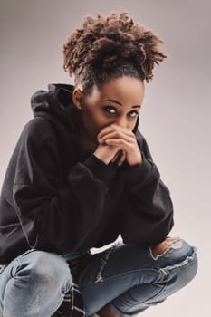 Playful yet poised, young female in casual wear engages viewers