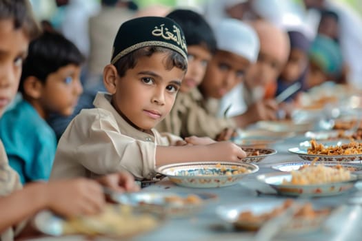 A boy wearing a taqiyah sits at a table during a shared meal, his thoughtful gaze drawing attention.