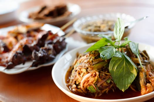 Local Thai food for people in the central region of Thailand. Spicy frog salad with vegetables and herbs. grilled chicken.