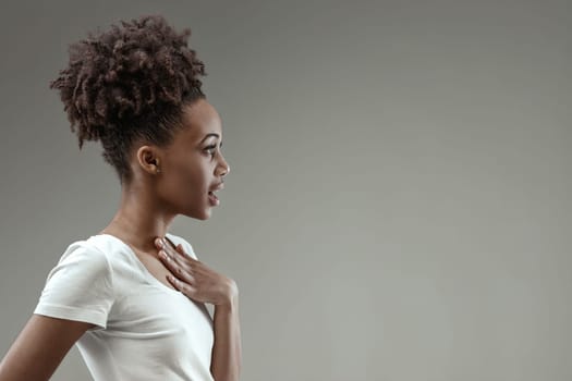 Astonishment crosses the woman's face, her hand on her chest, reacting to an unexpected honor
