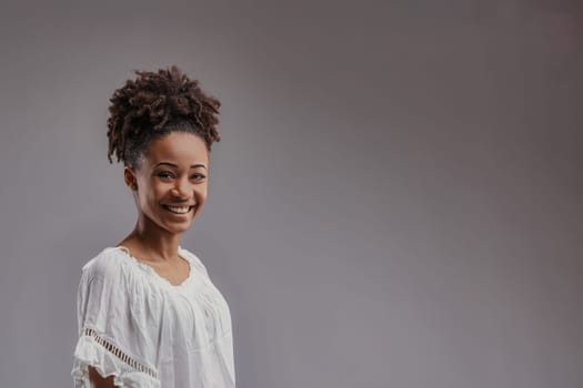 Radiant and carefree, the young womans smile is framed by her casual, bohemian-style white top near COPYSPACE