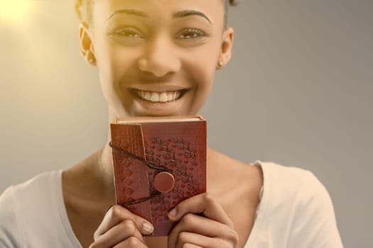 Glimpse into the soulful eyes of a young woman behind a red, embossed leather journal