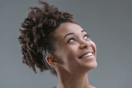 woman's cheerful countenance is captured as she looks upward, eyes sparkling with mirth