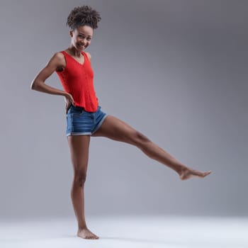 Full of vitality, she balances on one leg with an exultant smile
