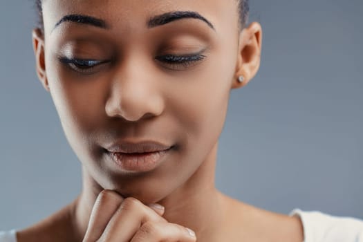Intimate close-up of a thoughtful young woman, her expression serene against a cool-toned background