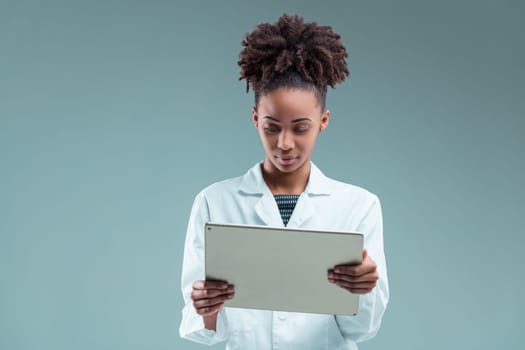 Professional young woman attentively examines a tablet, her intelligent gaze absorbed in the screen content