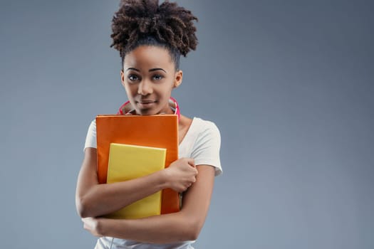 Studious young adult clutches educational materials with intent