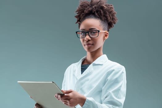 Engrossed in technology, the young professional woman navigates a tablet with a discerning eye