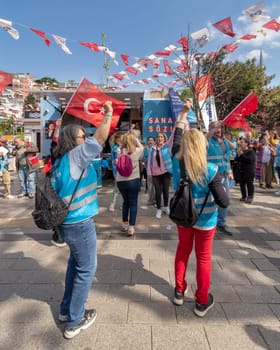 Istanbul, Turkey - May 13 2023: Supporters of Kemal Kilicdaroglu dancing while holding the Turkish flags in front of Republican Peoples Party kiosk in Uskudar neighbourhood during 2023 elections