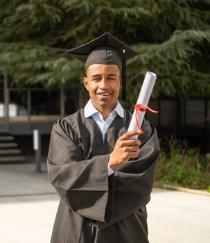 Happy young graduate holding diploma celebrating graduation from university
