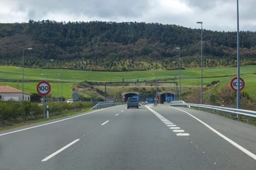 Driving along A-12 highway. Vehicules getting close to Erreniega Tunnel at Sierra del Perdon, Navarre, Spain