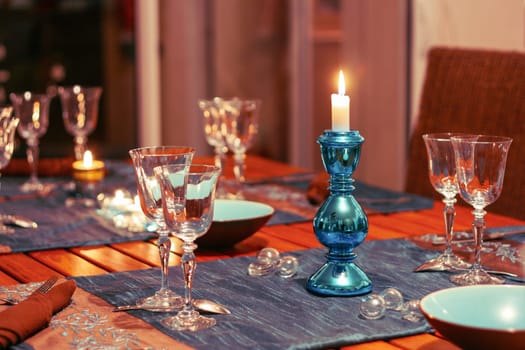 Dining table setting with glasses, festive decorations and candles