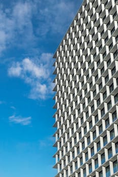 Geometric facade of a contemporary building with a clear blue sky backdrop