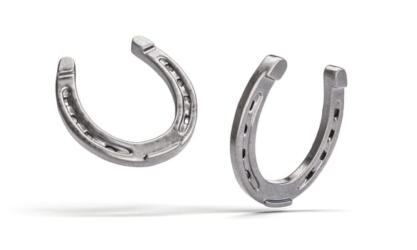 Two shiny metal horseshoes facing each other isolated on a white backdrop