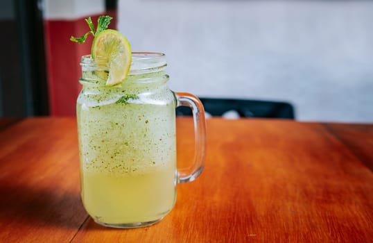 Lemonade drink on wooden background. Refreshing lemonade with mint on wooden table