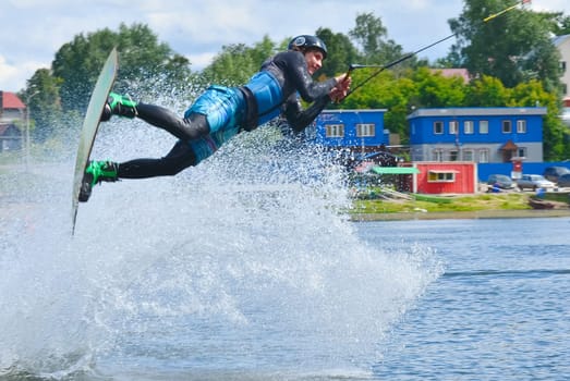 Russia, Volgodonsk - June 18, 2015: Water snowboard. The athlete with snowboard hold on to the rope and the boat accelerates.