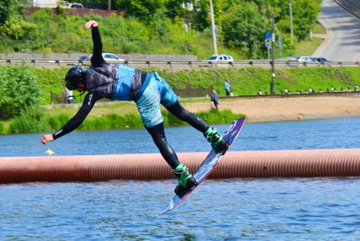 Russia, Volgodonsk - June 18, 2015: Water snowboard. The athlete with snowboard hold on to the rope and the boat accelerates.