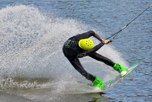 Russia, Volgodonsk - June 18, 2015: Water snowboard. The athlete with snowboard hold on to the rope and the boat accelerates.