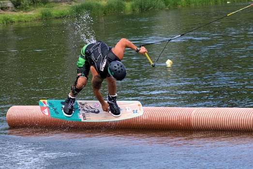 Russia, Volgodonsk - June 18, 2015: Water snowboard. The athlete with snowboard hold on to the rope and the boat accelerates.