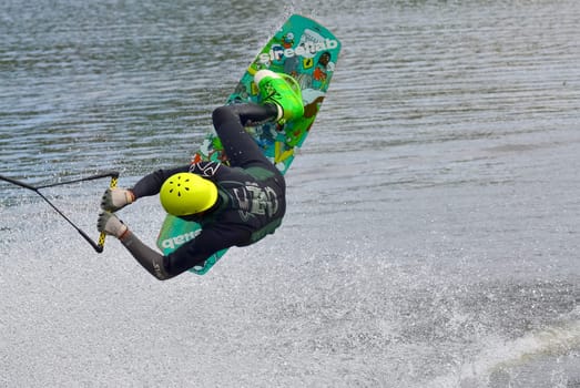 Russia, Volgodonsk - June 18, 2015: Water snowboard. The athlete with snowboard hold on to the rope and the boat accelerates.