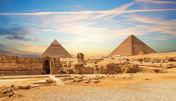 The Great Sphinx next to the Pyramids of Egypt at sunset, Giza desert.