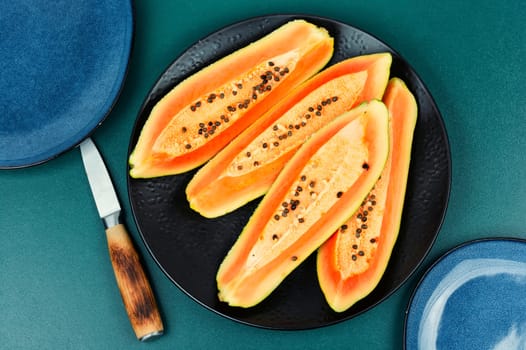 Sliced fresh juicy papaya on the table. Papaya exotic fruits. Top view.