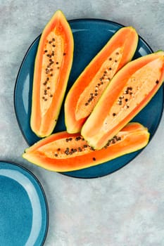 Sliced fresh juicy papaya on the table. Papaya exotic fruits. Top view.