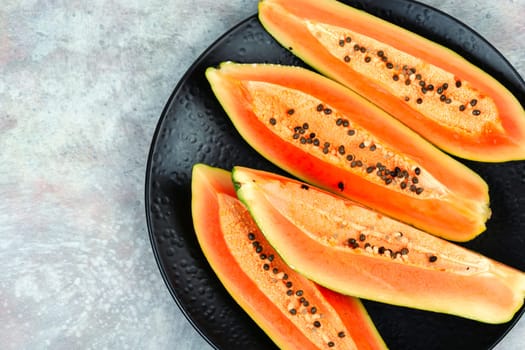 Sliced fresh juicy papaya on the table. Papaya exotic fruits. Top view.