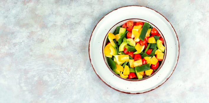 Vegetable salad with bell pepper, tomato, avocado and runner beans in bowl on rustic wooden table. Rustic style.