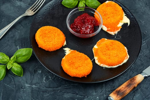 Baked or fried Camembert cheese with berry sauce. Flat lay.