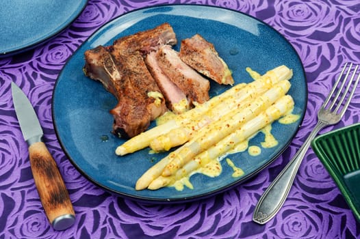 Juicy fried meat steak with boiled white asparagus.