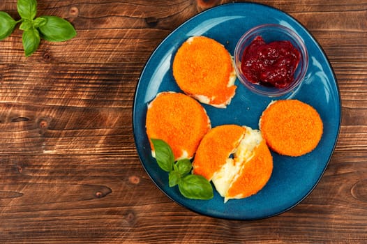 Baked or fried Camembert cheese with berry sauce. Flat lay.