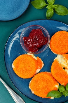 Baked or fried Camembert cheese with berry sauce. Flat lay.