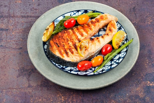 Fried salmon steak and grilled potatoes and green beans. Grilled fish.