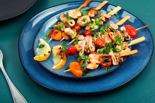 Grilled squid, fried mussels and shrimp on wooden skewers. Seafood appetizers.