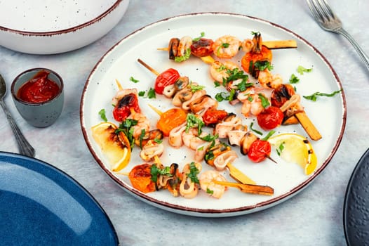 Grilled squid, fried mussels and shrimp on wooden skewers. Seafood appetizers.