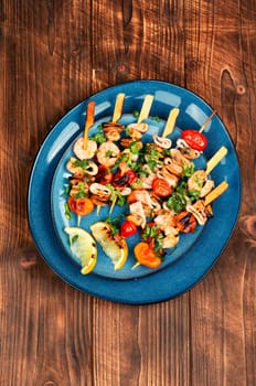 Grilled squid, fried mussels and shrimp on wooden skewers. Seafood appetizers.