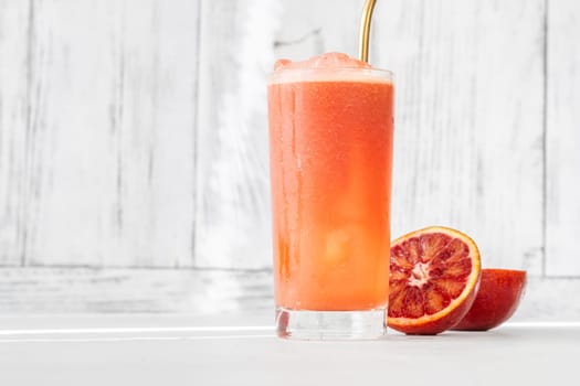 Glass of blood red orange juice on white background