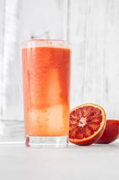 Glass of blood red orange juice on white background