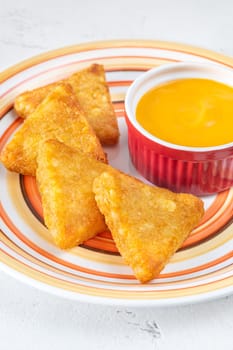 Hash Browns patties with cheddar cheese sauce