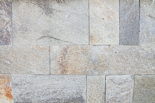Wall cladding of horizontally arranged stones. Selective focus with shallow depth of field.