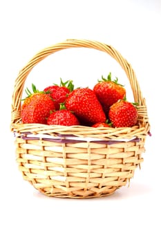 Ripe red strawberries in a small wicker basket. Selective focus with shallow depth of field.