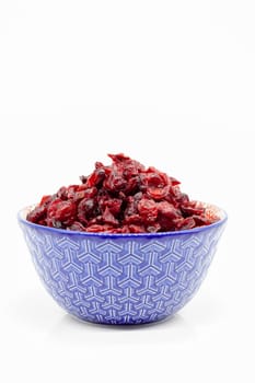 Dried cranberries in a porcelain bowl. Selective focus with shallow depth of field.