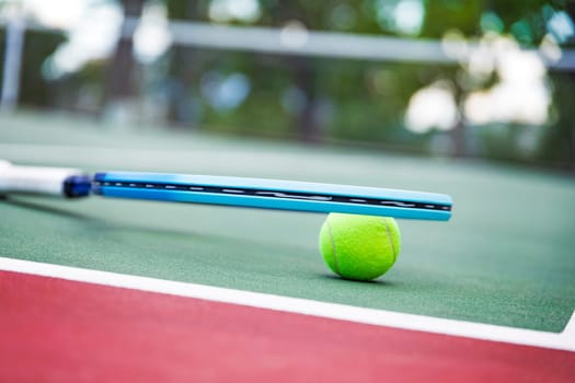 Tennis racket and ball on the court. Close-up.