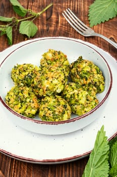 Vegetarian cutlets of cutlet nettles leaves and broccoli. Fried nettle meat balls on wooden rustic table