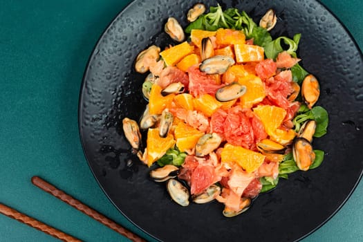 Salad with citrus fruits and mussels, dieting eating. Healthy food concept.